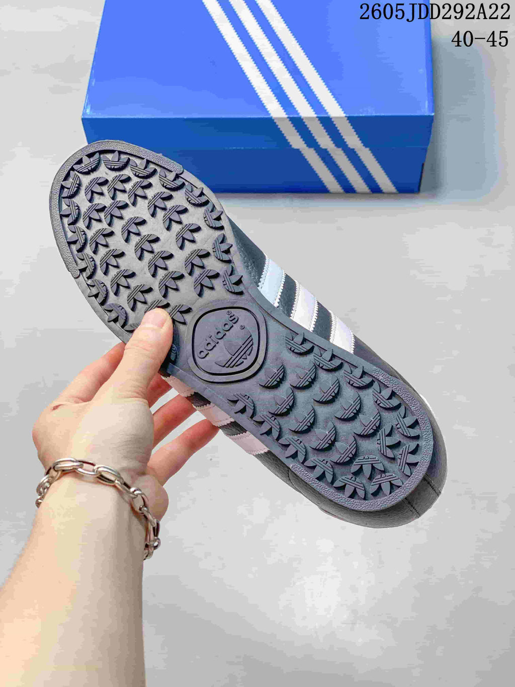 Close-up of the patterned outsole on a charcoal Adidas Samoa sneaker