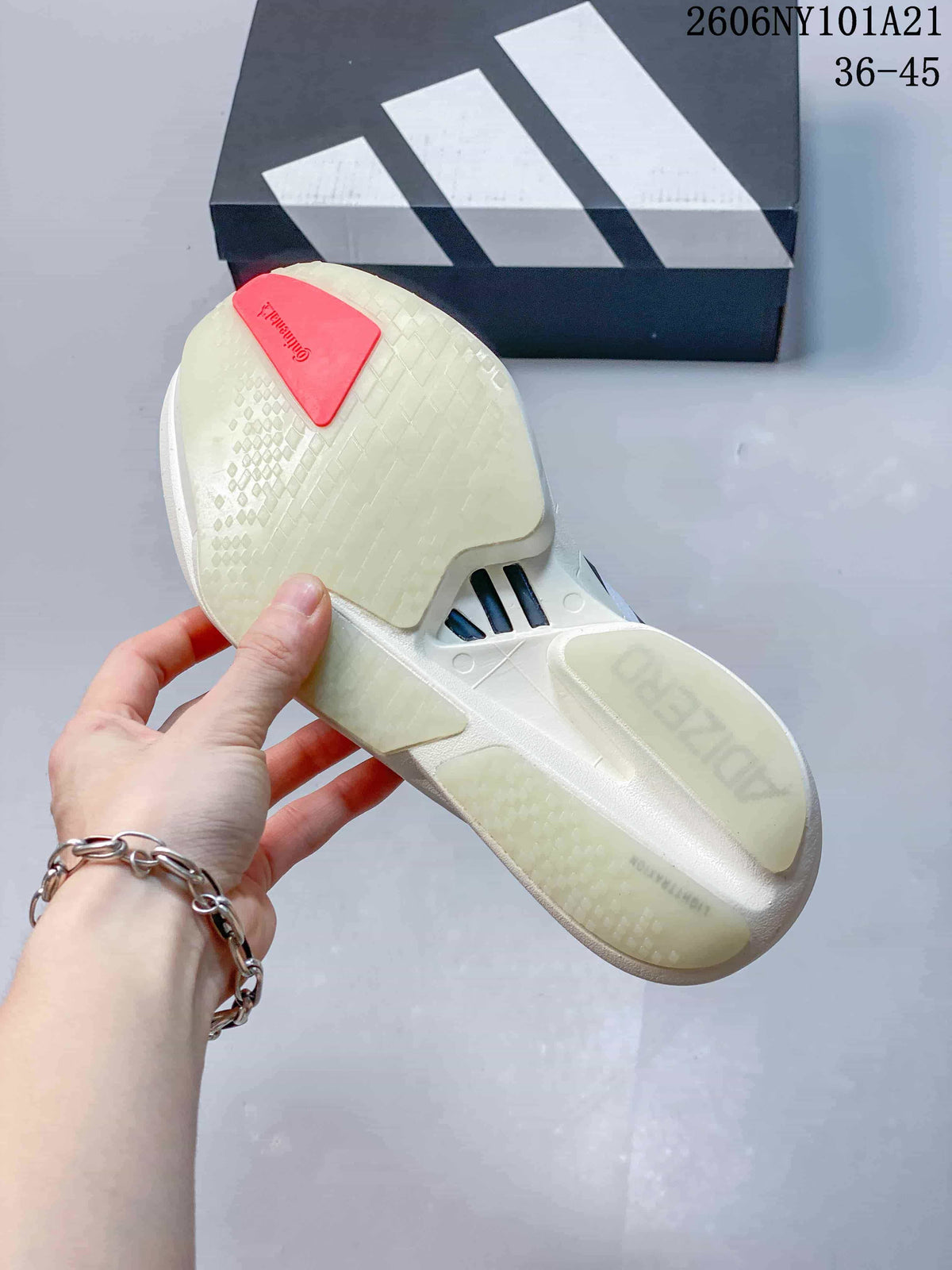 Underside of a white Adidas shoe showing a pale patterned sole and orange-red heel section.