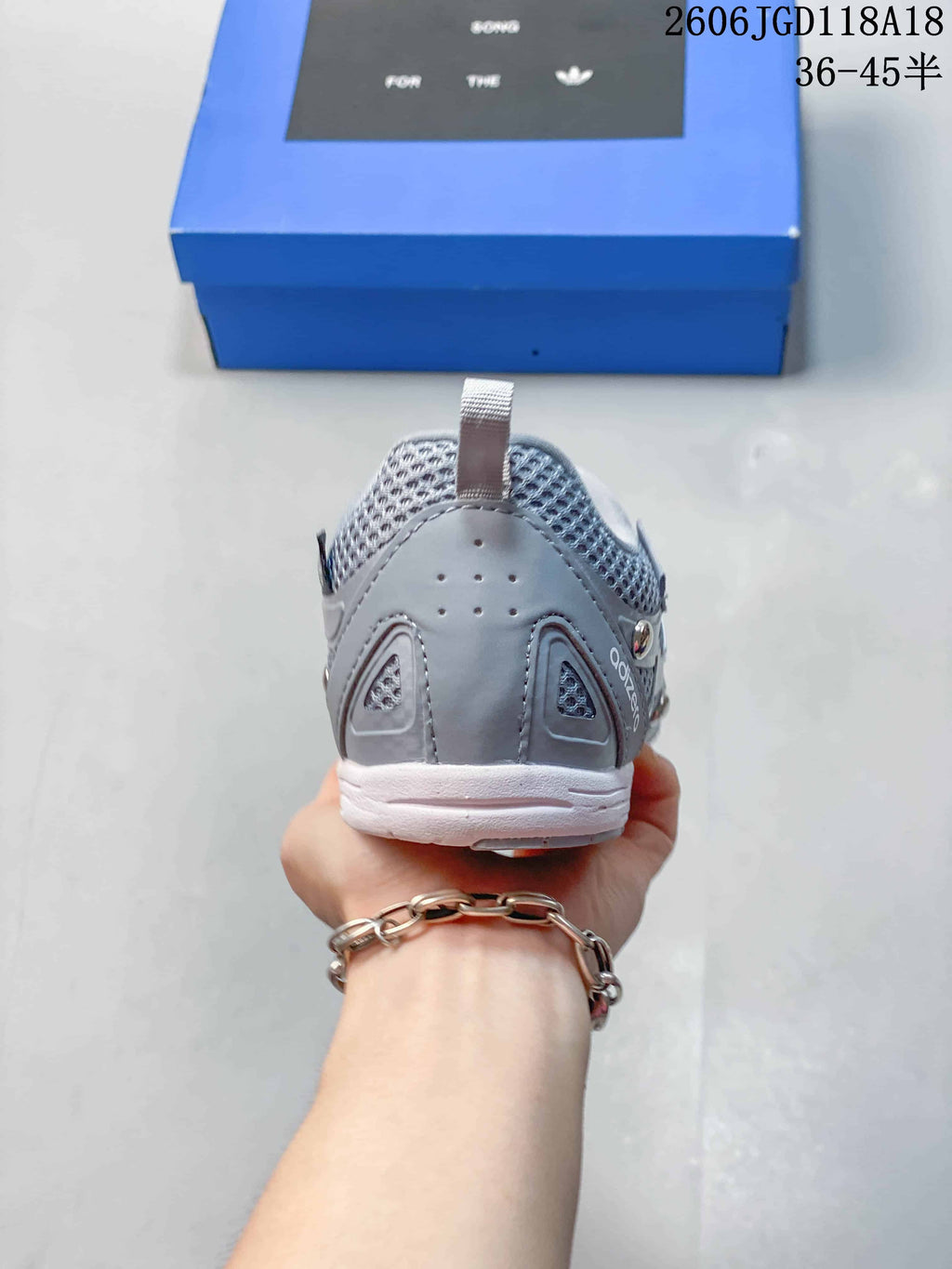 Rear view of a grey sneaker with mesh panels and a heel pull tab