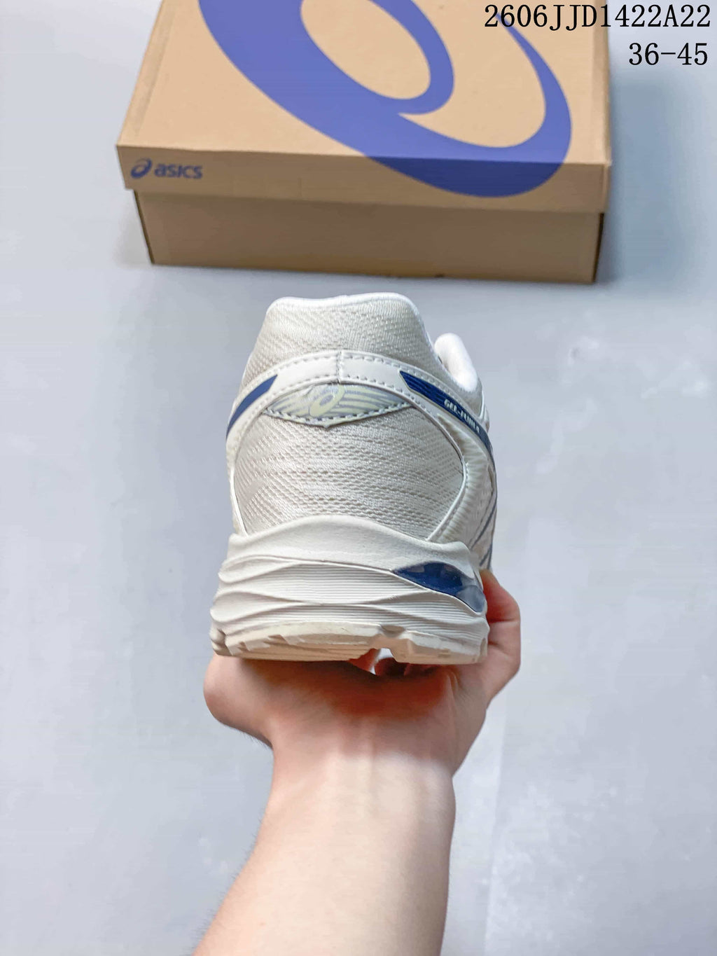 Rear view of a white ASICS shoe with blue heel details