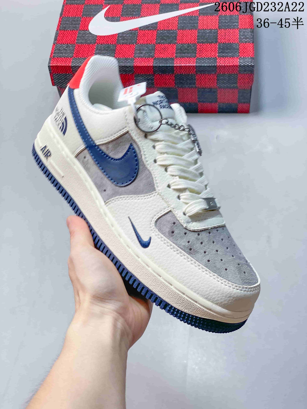 Angled view of the sneaker showing its white, grey and blue color blocking and red heel tab.