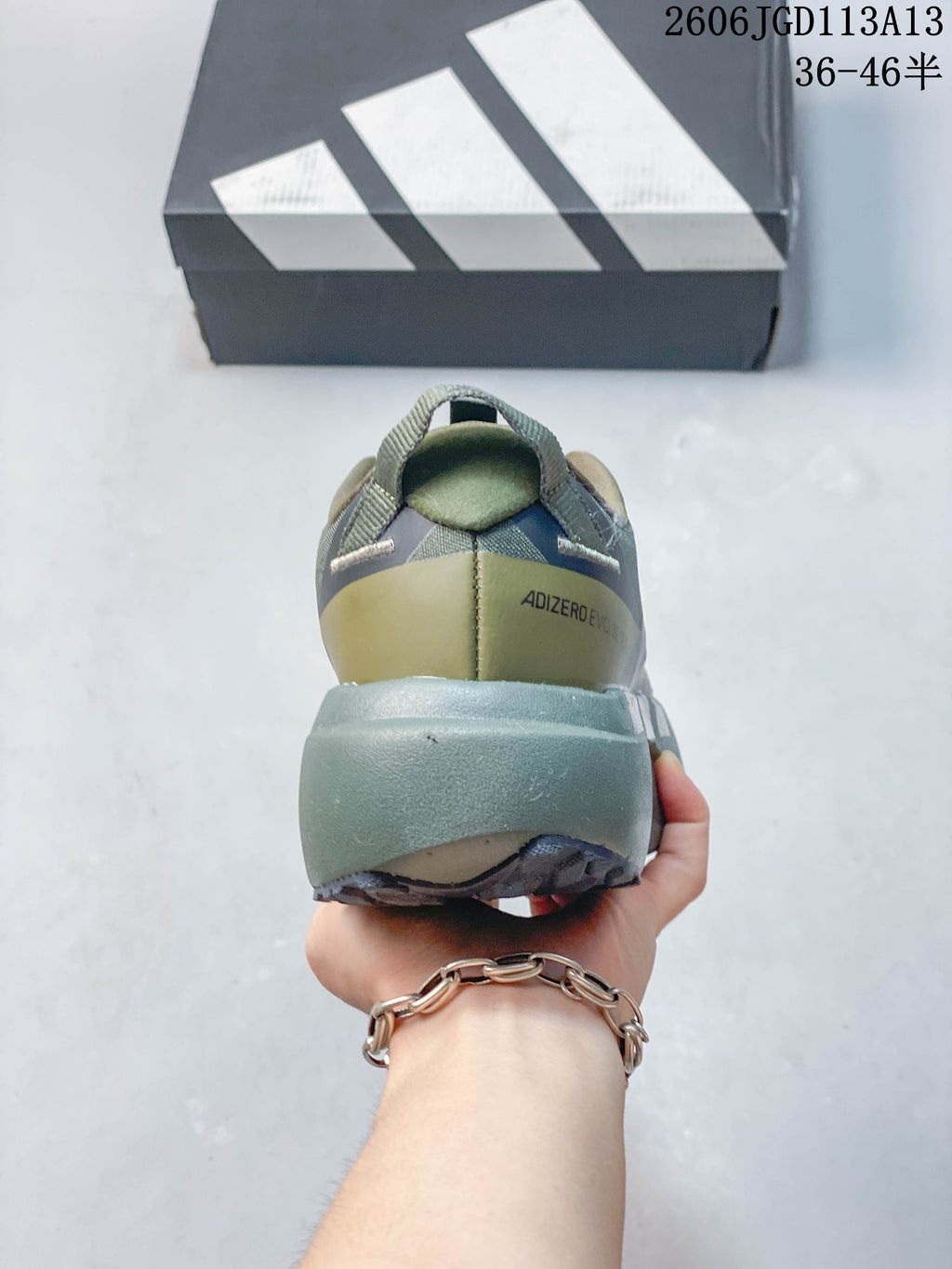 Rear view showing the heel and thick midsole of an olive running shoe