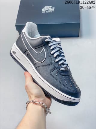 Handheld side view of a black Nike Air Force 1 sneaker with contrasting sole detailing, Swoosh branding, and Air lettering.