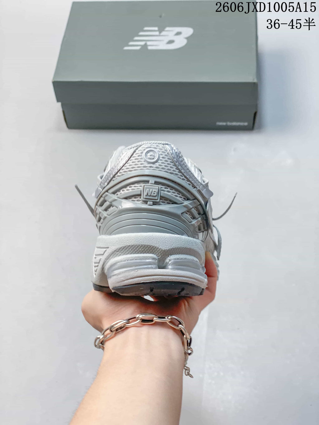 Rear view showing the heel and sculpted sole of a silver-grey sneaker