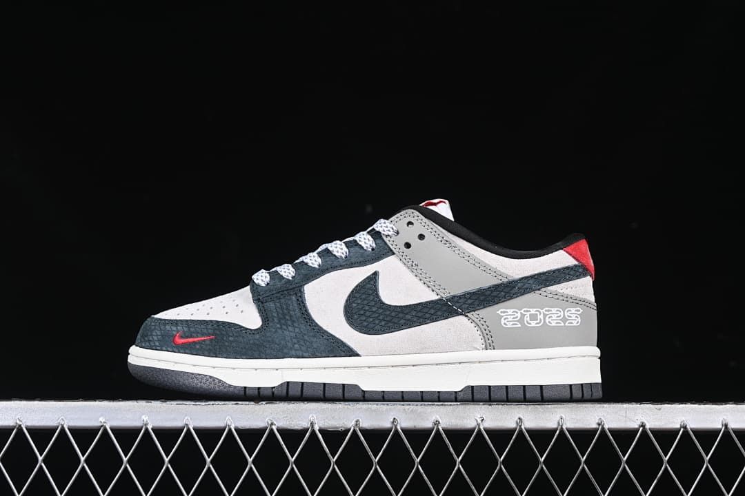 Side view of navy, gray, white, and red Nike SB Dunk Low sneakers