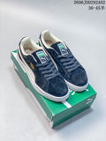 Pair of navy Puma Suede XL low-top sneakers with light side detailing and white soles on a green Puma box.