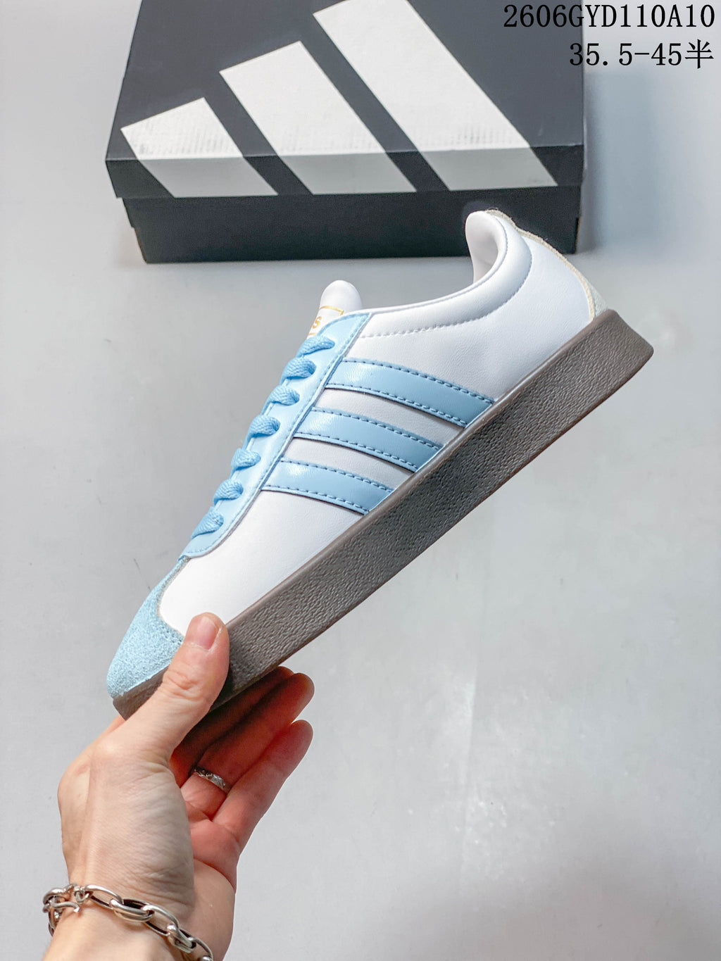 Side profile showing the white upper, light-blue stripes, and suede-look toe panel