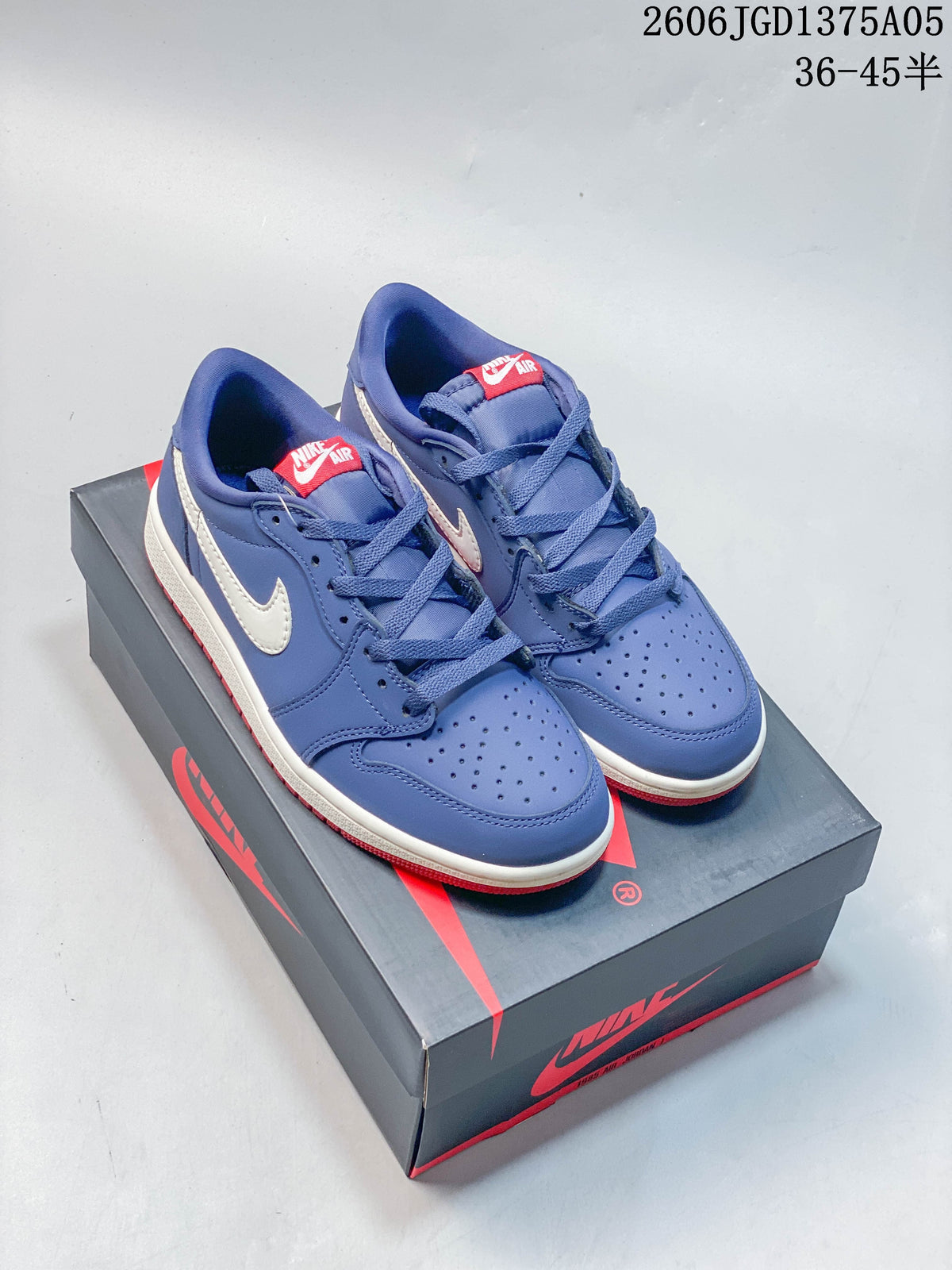 Pair of blue, white, and red Jordan 1 Low sneakers displayed on a shoe box