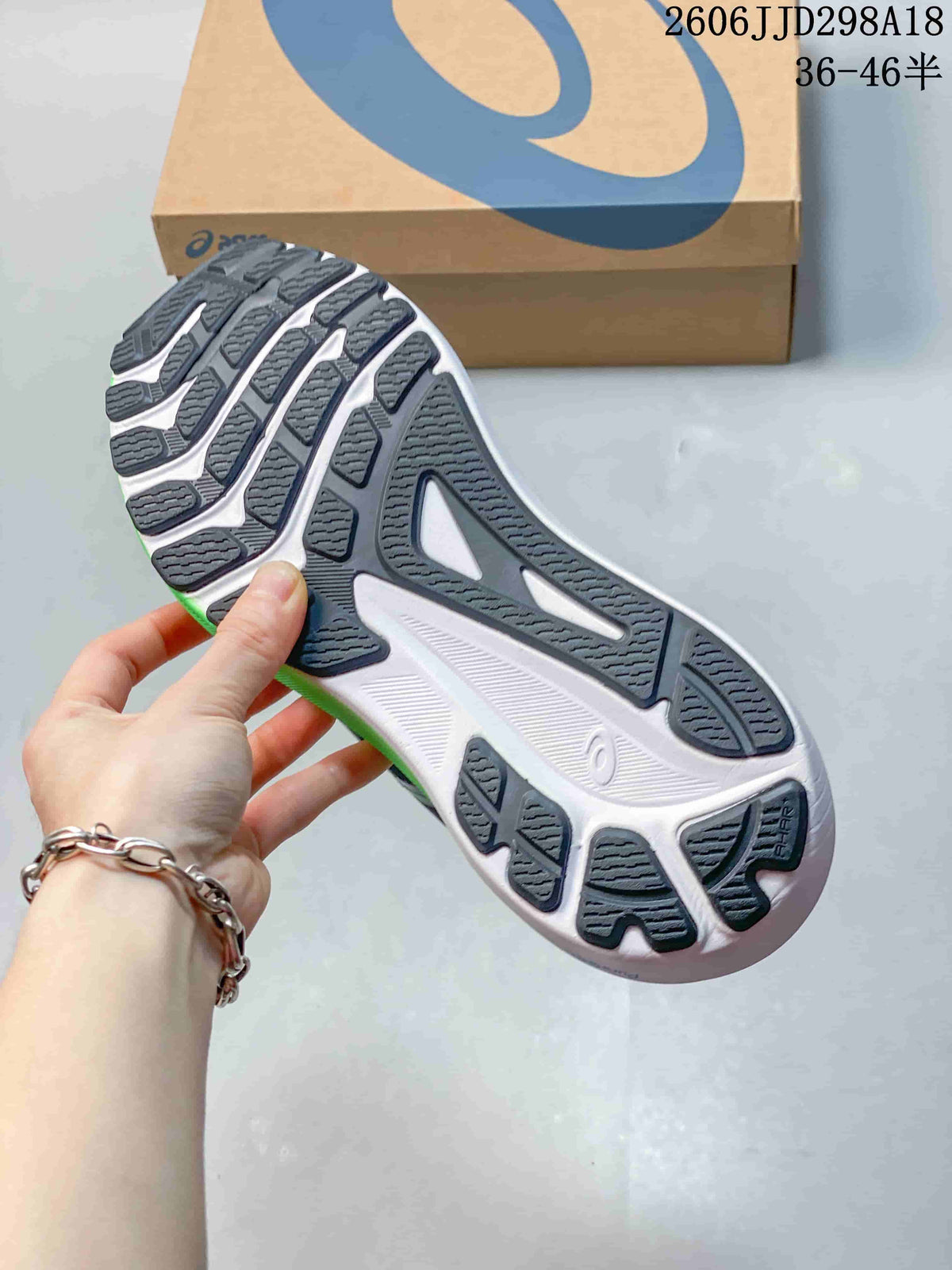 Close-up of the patterned outsole on a navy ASICS running shoe.