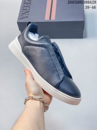 Side view of a navy Zegna Tiziano sneaker with a textured upper and white outsole; box shows size range 39–46.