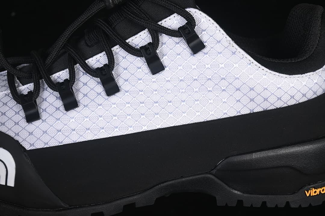 Close-up of the patterned upper, lace loops, and black overlay.