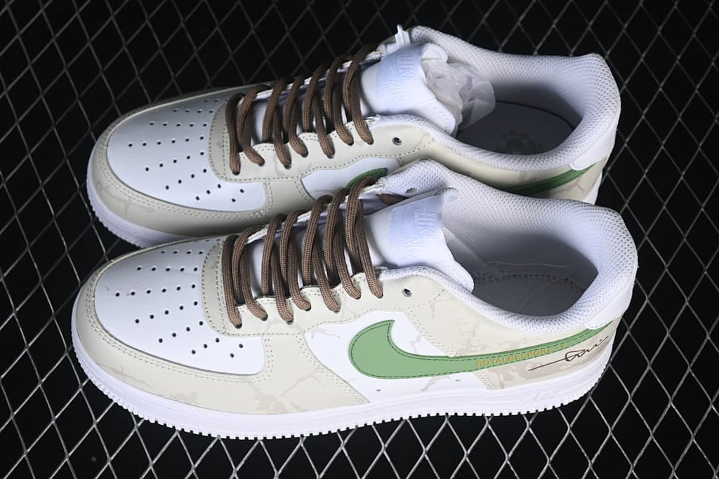 Pair of white and cream low-top sneakers with green accents and brown laces