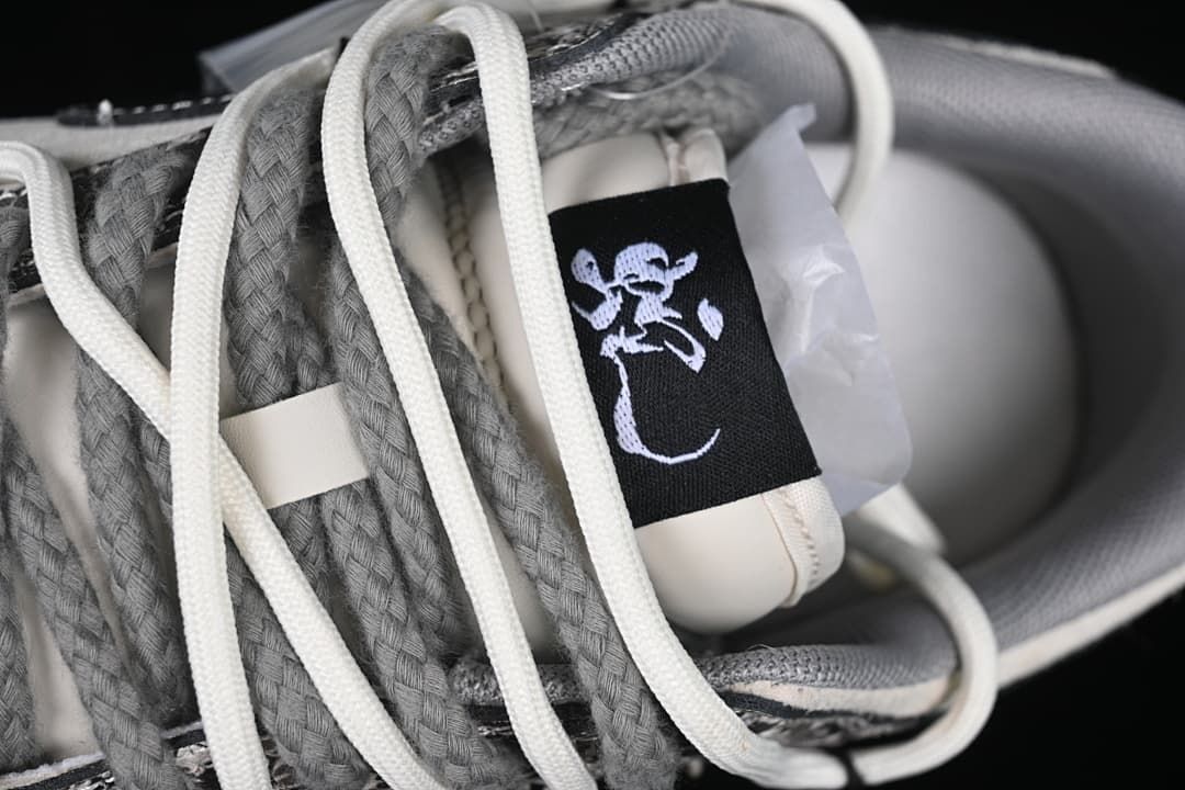 Close-up of the tongue label and layered gray and ivory laces