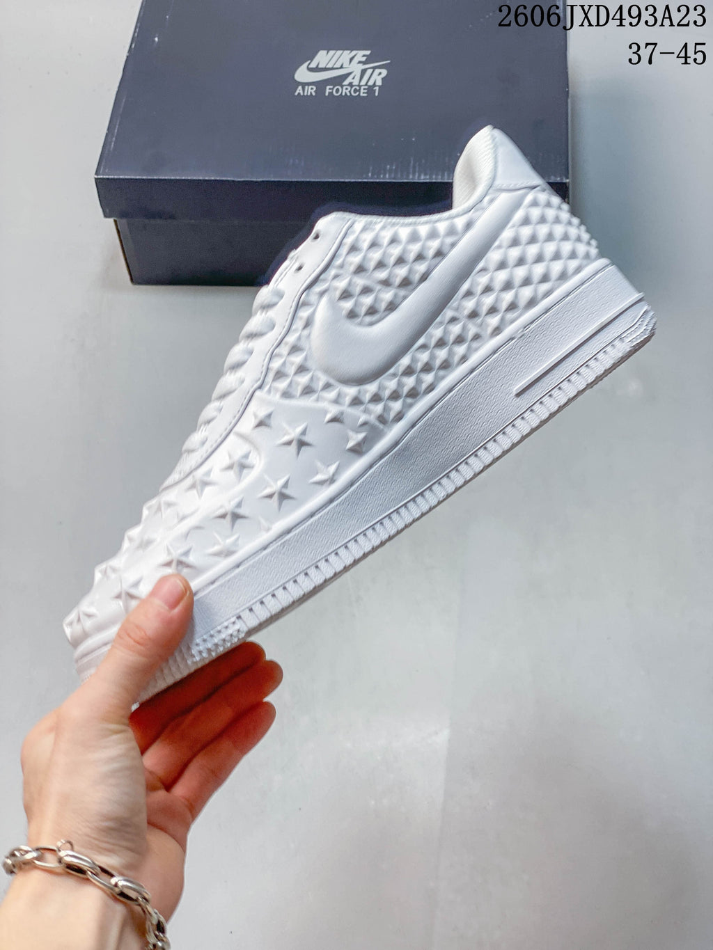 Side view of the white sneaker showing star details, Swoosh, and textured panels