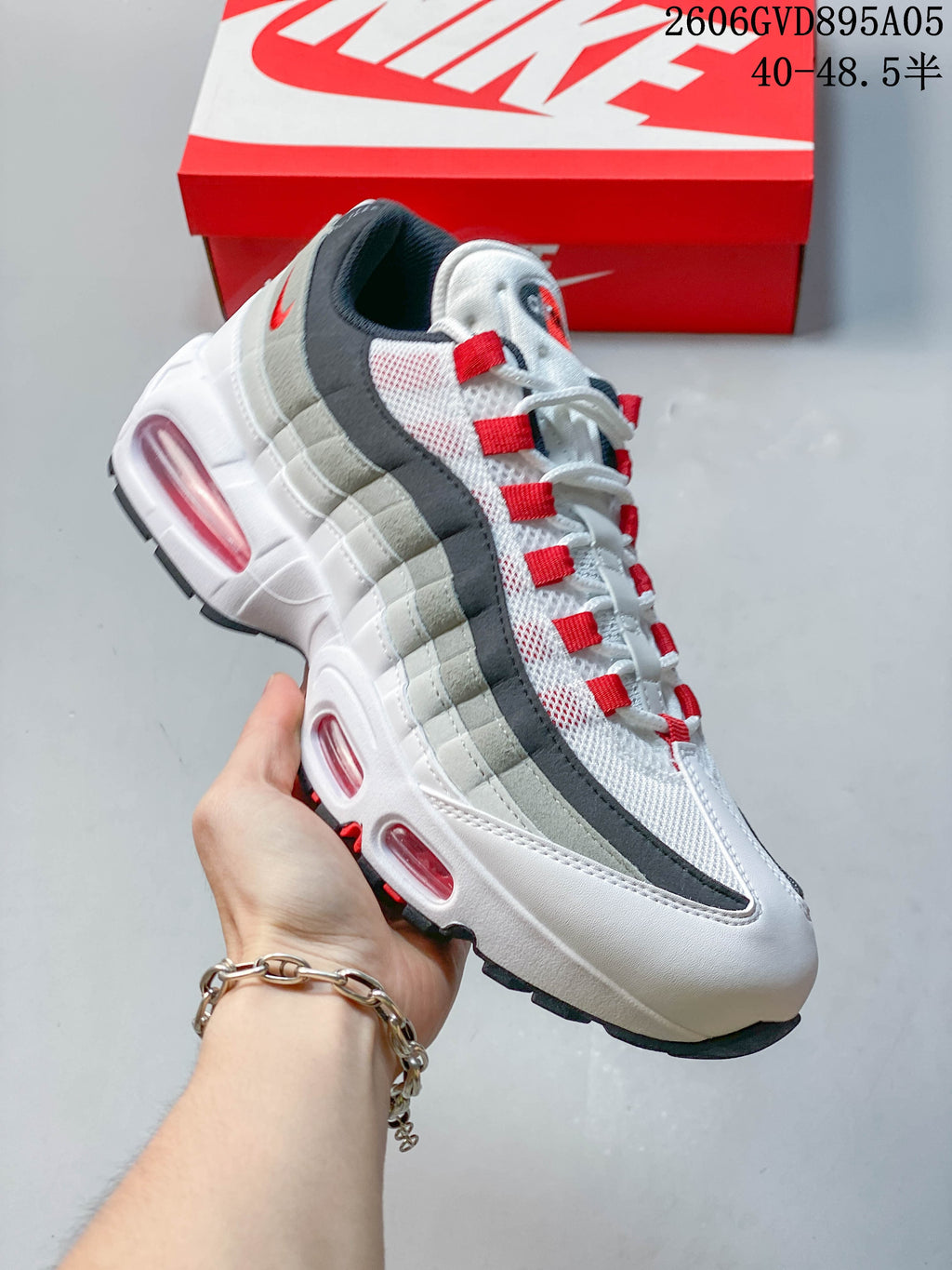 Angled side view of the white, grey, and red Nike Air Max 95 Big Bubble sneaker.