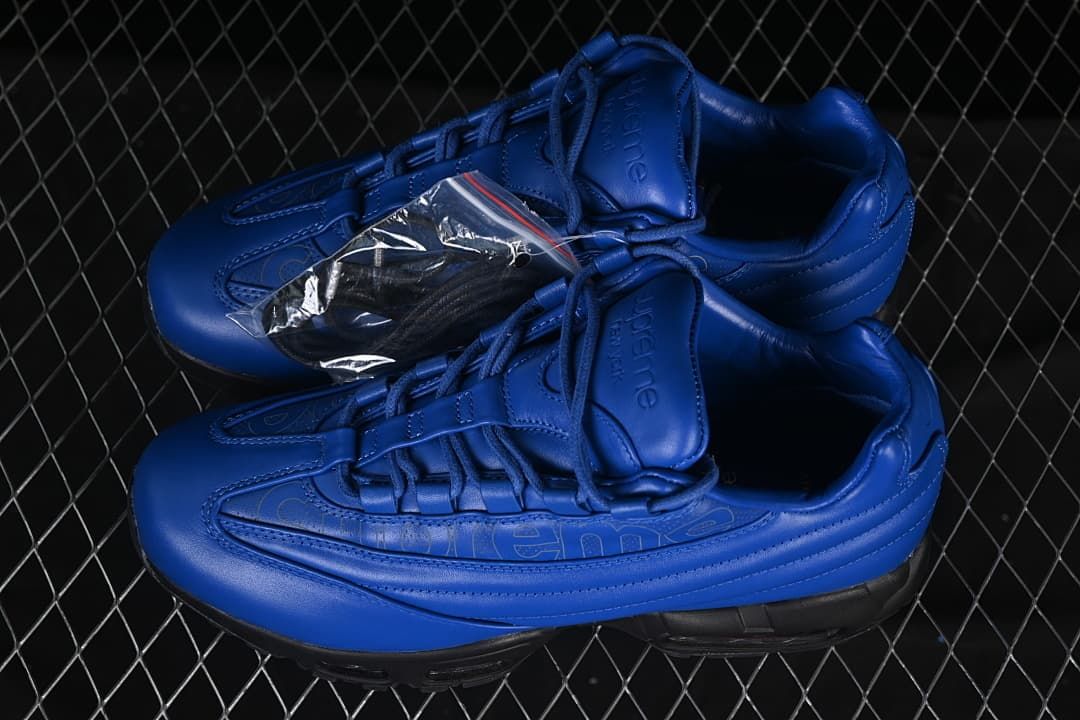 Pair of blue sneakers with a small accessory packet shown alongside.