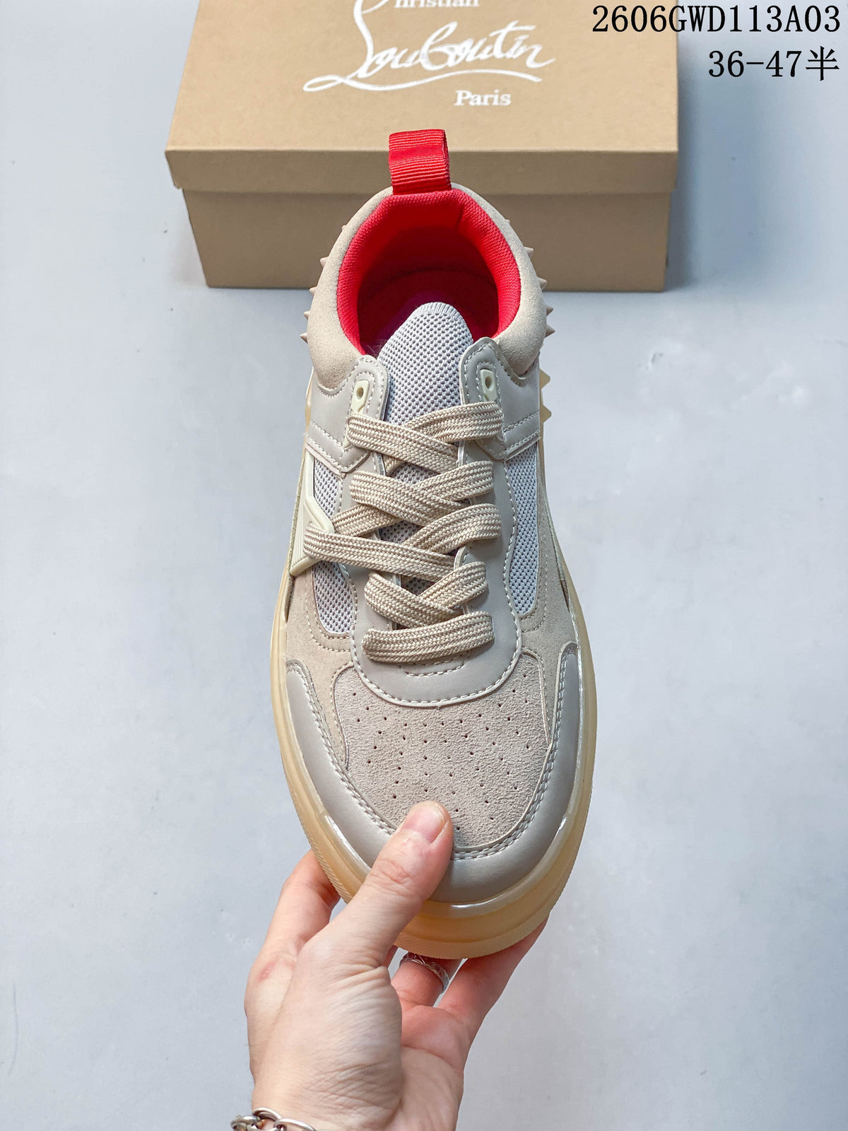 Top view of a lace-up sneaker showing its round toe, mesh panels, and red lining