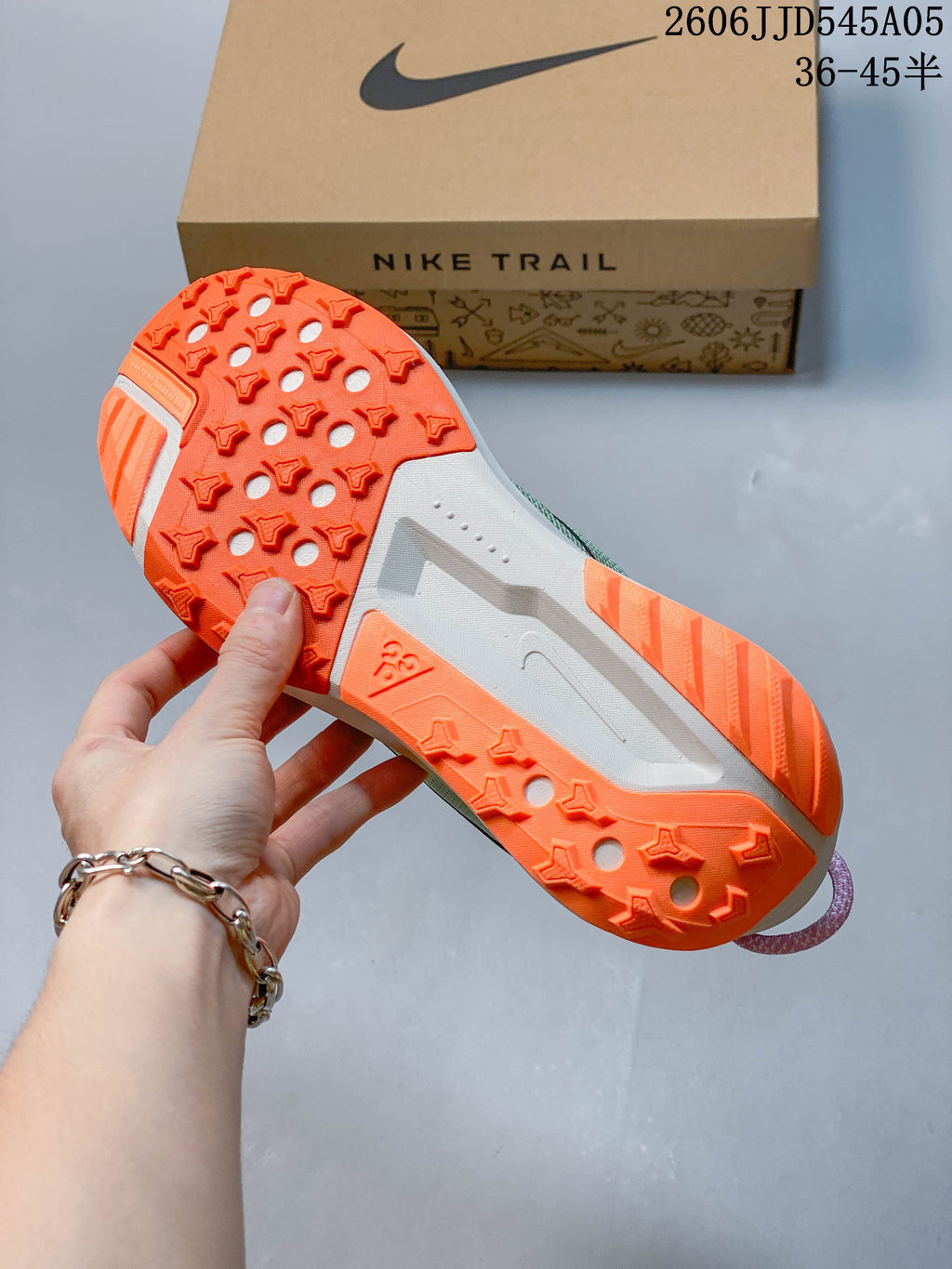 Close view of the orange lugged outsole on a Nike ACG Pegasus Trail 6 shoe.
