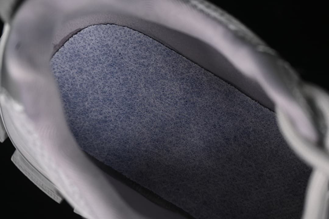 Close-up view inside the sneaker, showing the footbed and padded collar.