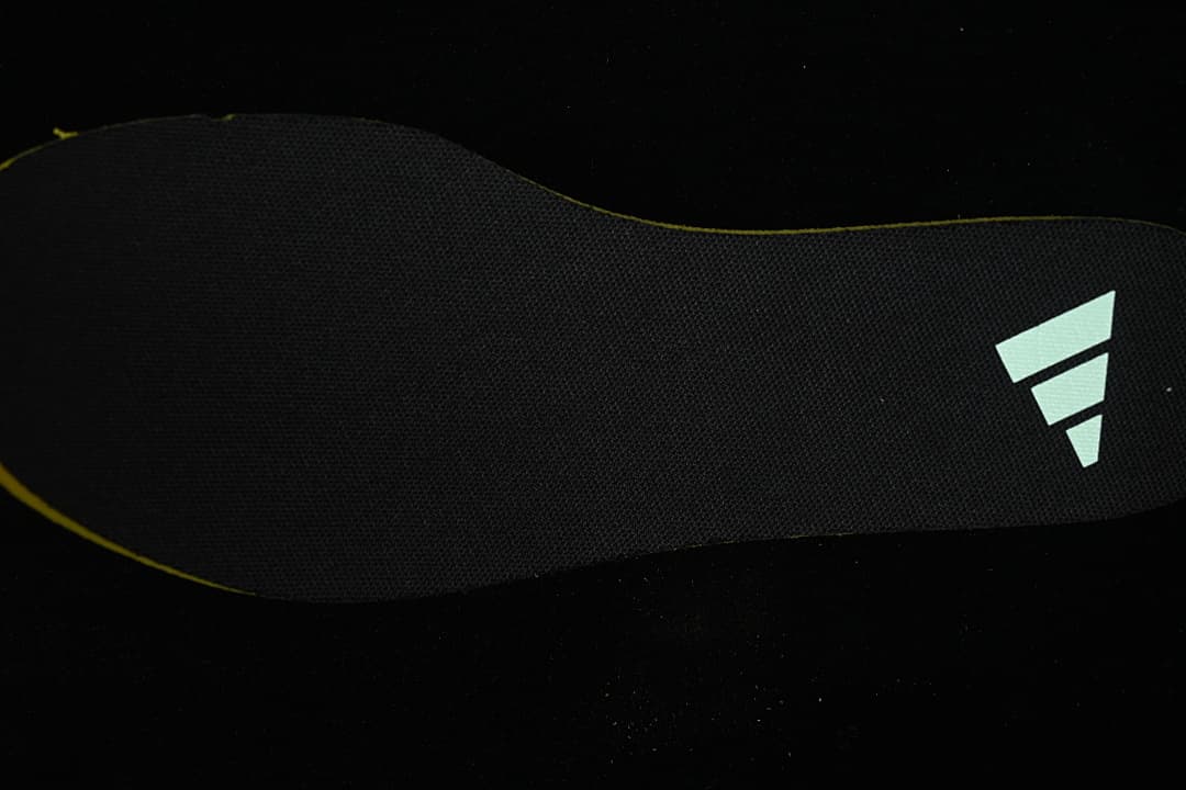 Black shoe insole with a pale Adidas logo