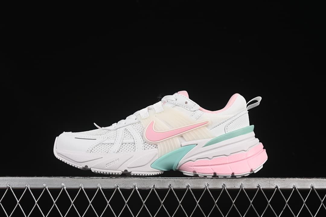 Side view of white Nike V2K Run sneakers with pink and mint accents