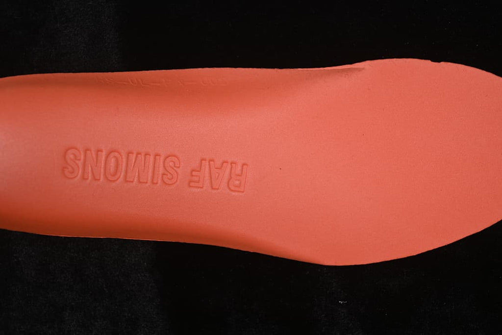 Coral-colored insole underside embossed with Raf Simons branding