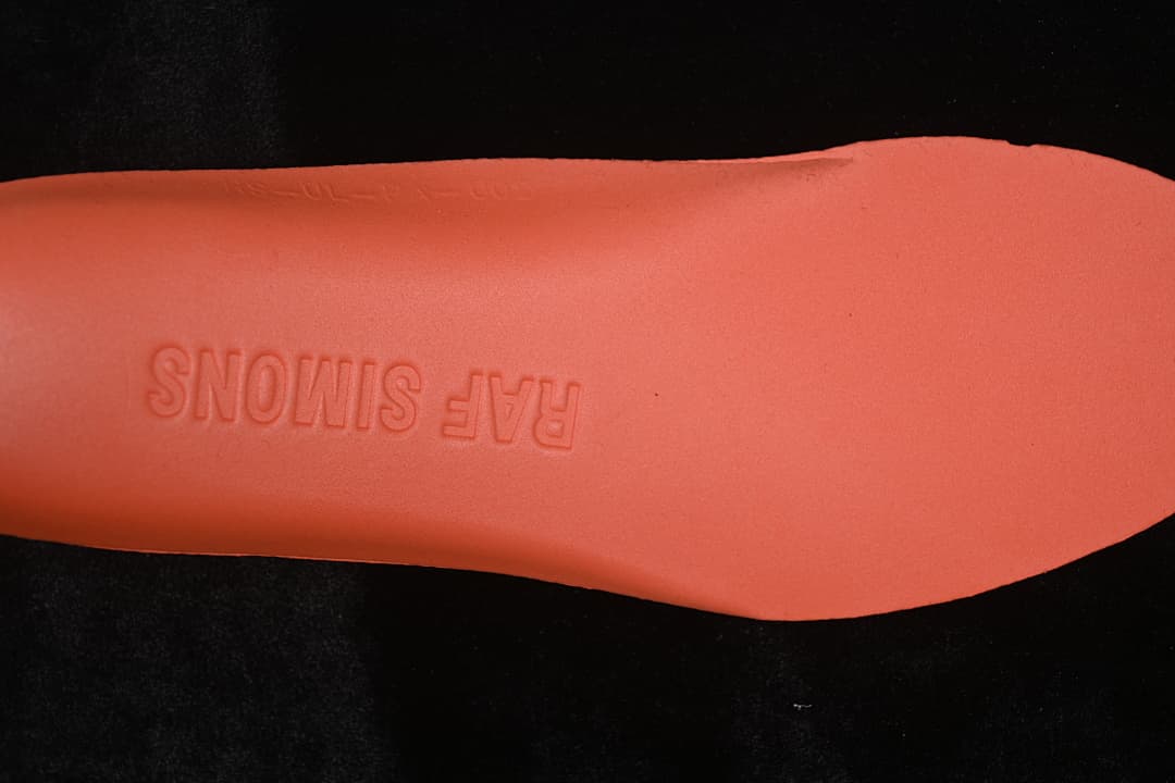 Coral-colored insole underside embossed with Raf Simons branding