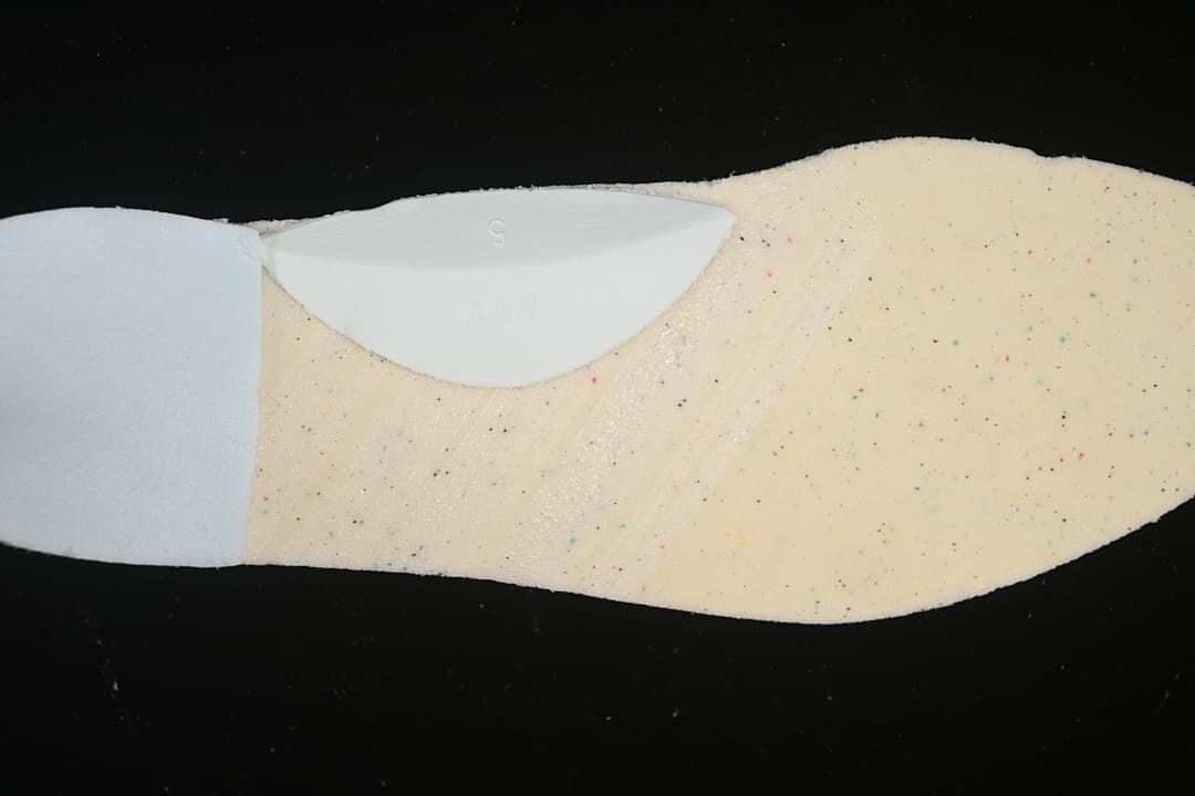 Close-up of a light-colored shoe insert with multicolored speckles