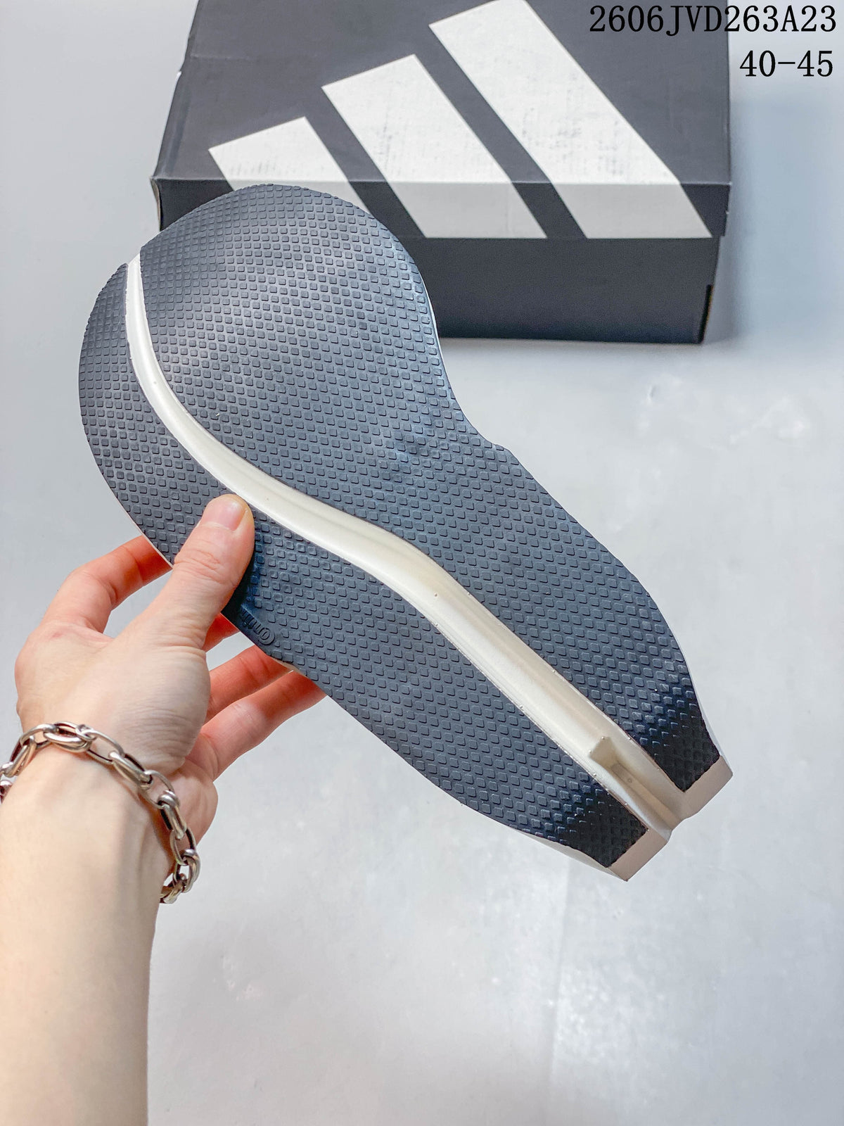 Close-up of the textured dark outsole on a white Adidas shoe; image overlay states sizes 40–45.