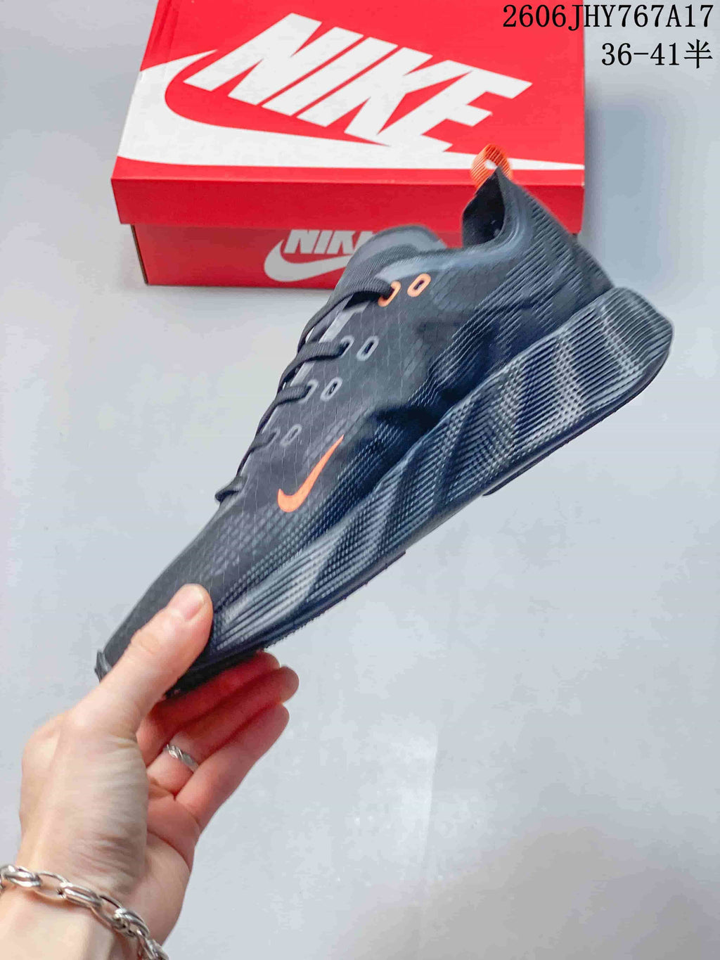 Side profile of a dark gray Nike Ava Rover sneaker with orange Swoosh detailing.