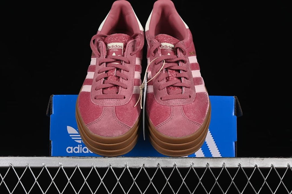 Front view of the pink sneakers resting on the shoe box
