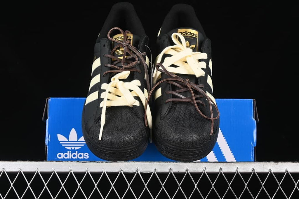 Front view of the pair showing textured black shell toes and cream stripes.