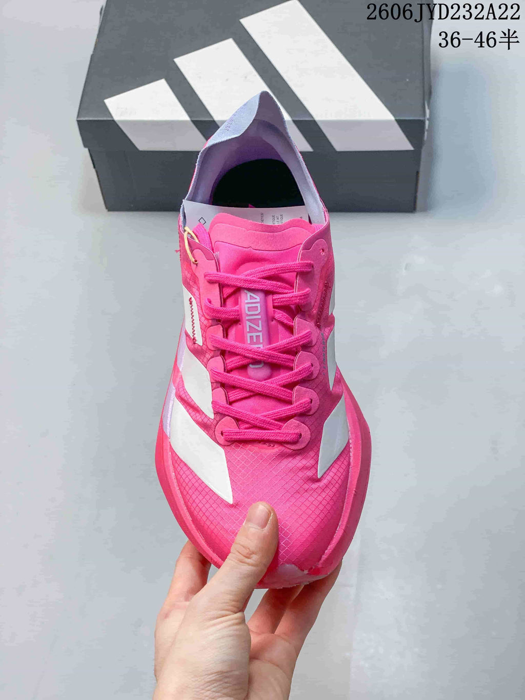 Top view of a pink lace-up running shoe with white side stripes.