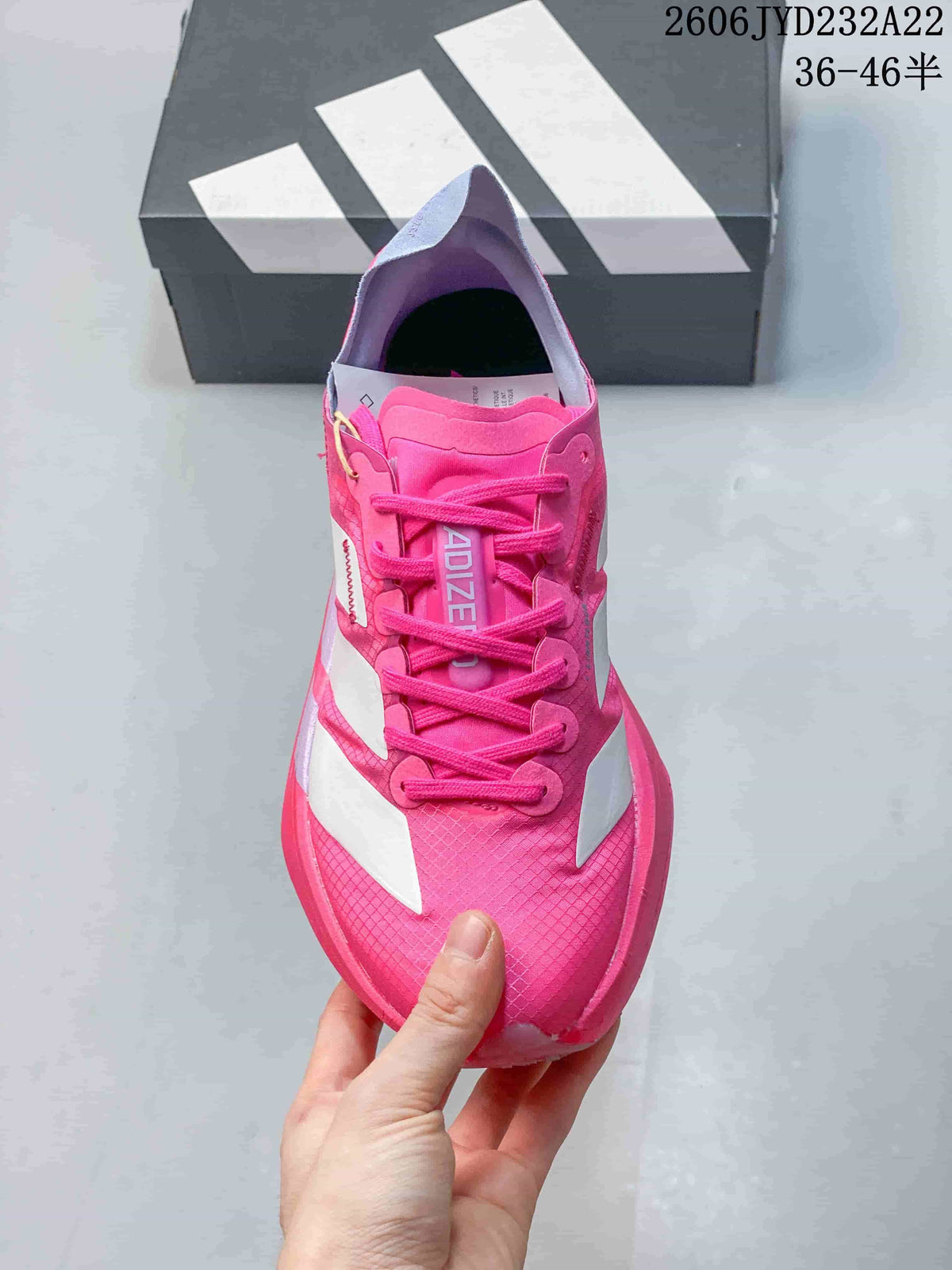 Top view of a pink lace-up running shoe with white side stripes.