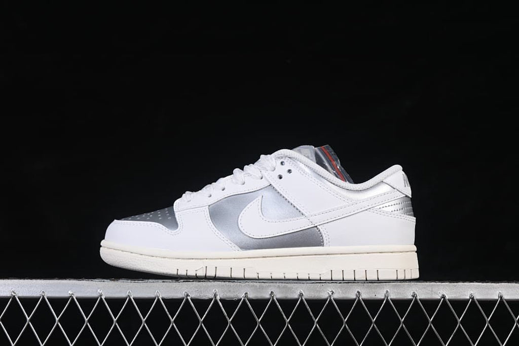Side view of a white and silver Nike SB Dunk Low sneaker