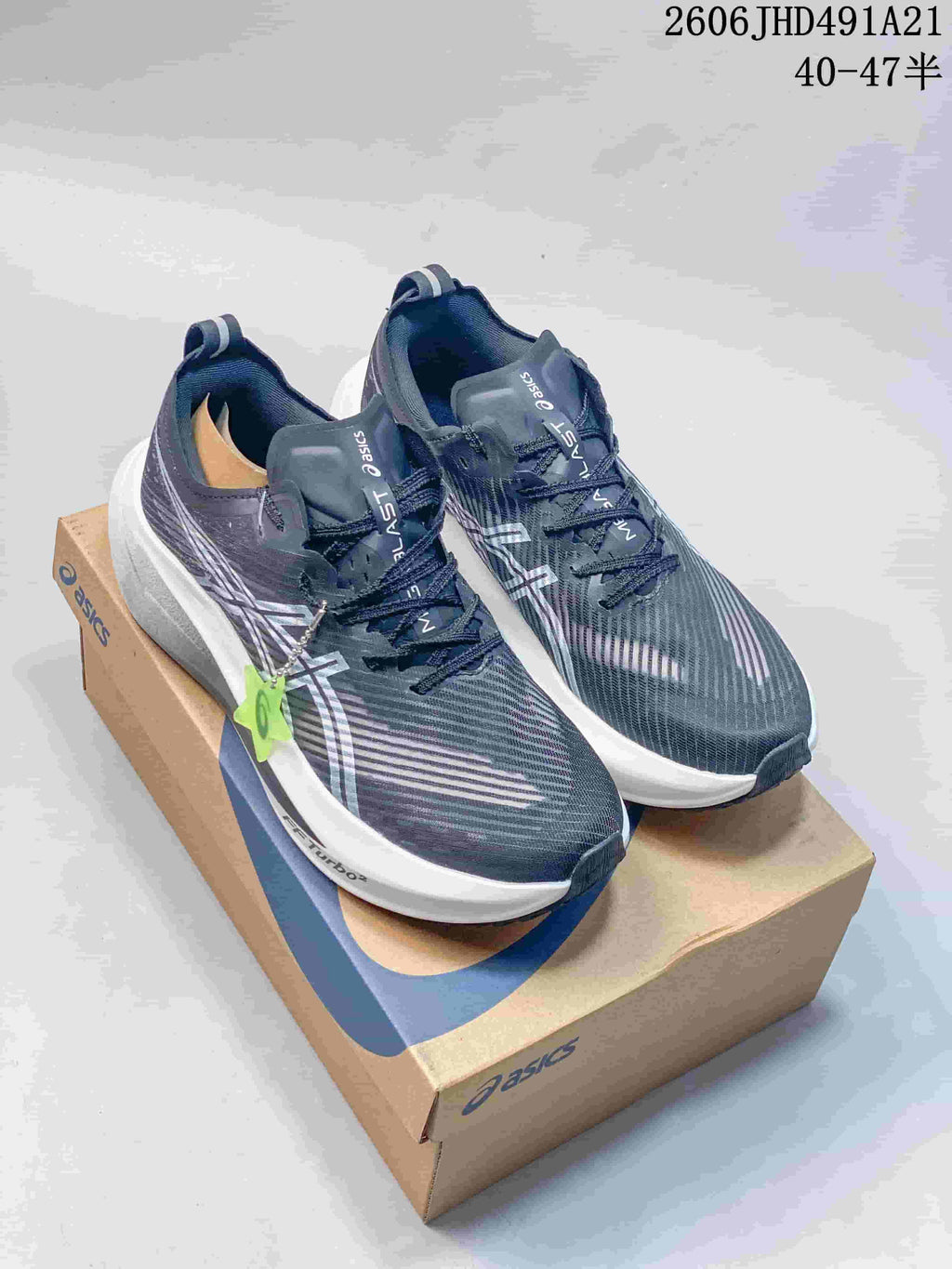 Pair of charcoal ASICS MEGABLAST running shoes on a shoe box