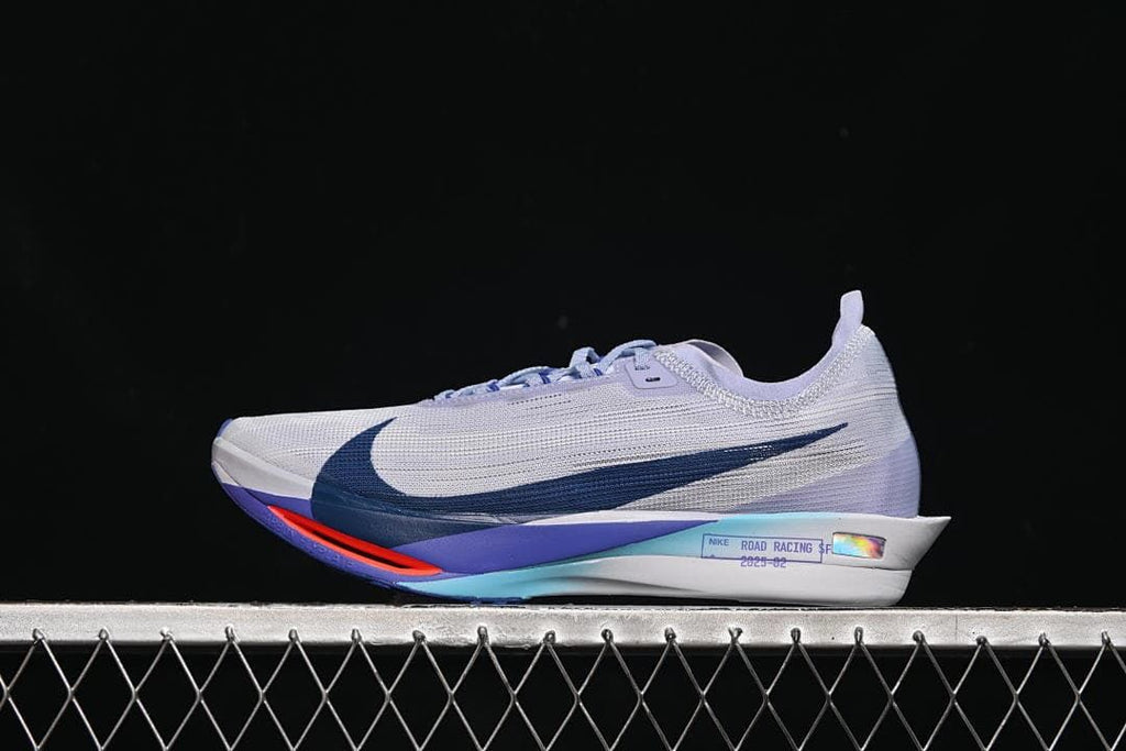 Side view of a light gray Nike ZoomX Streakfly 2 with dark blue swoosh and lavender and coral accents.