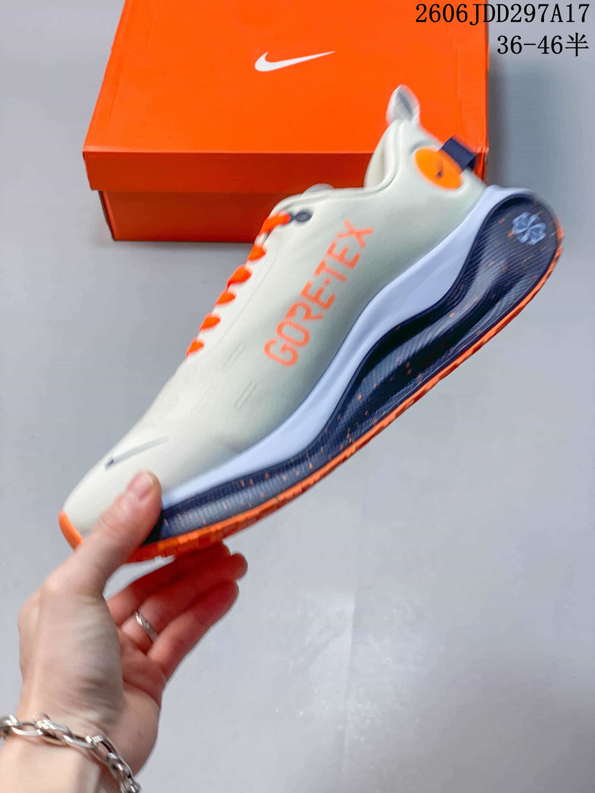 Side view of a light gray Nike InfinityRN 4 shoe with orange GORE-TEX lettering and dark blue accents.