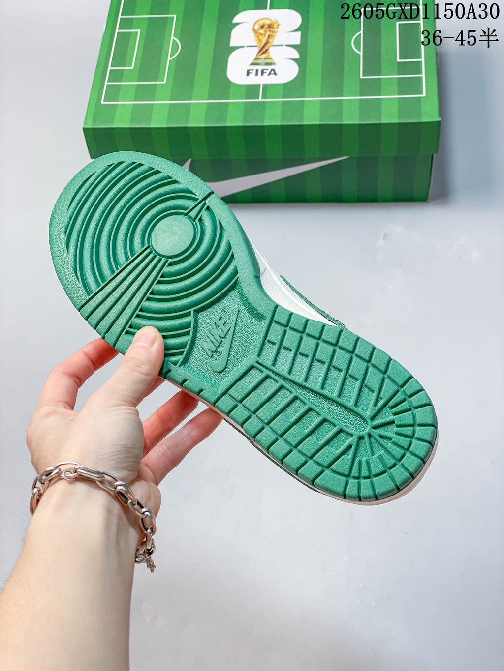 Green outsole of the sneaker shown beside a football-field graphic box.