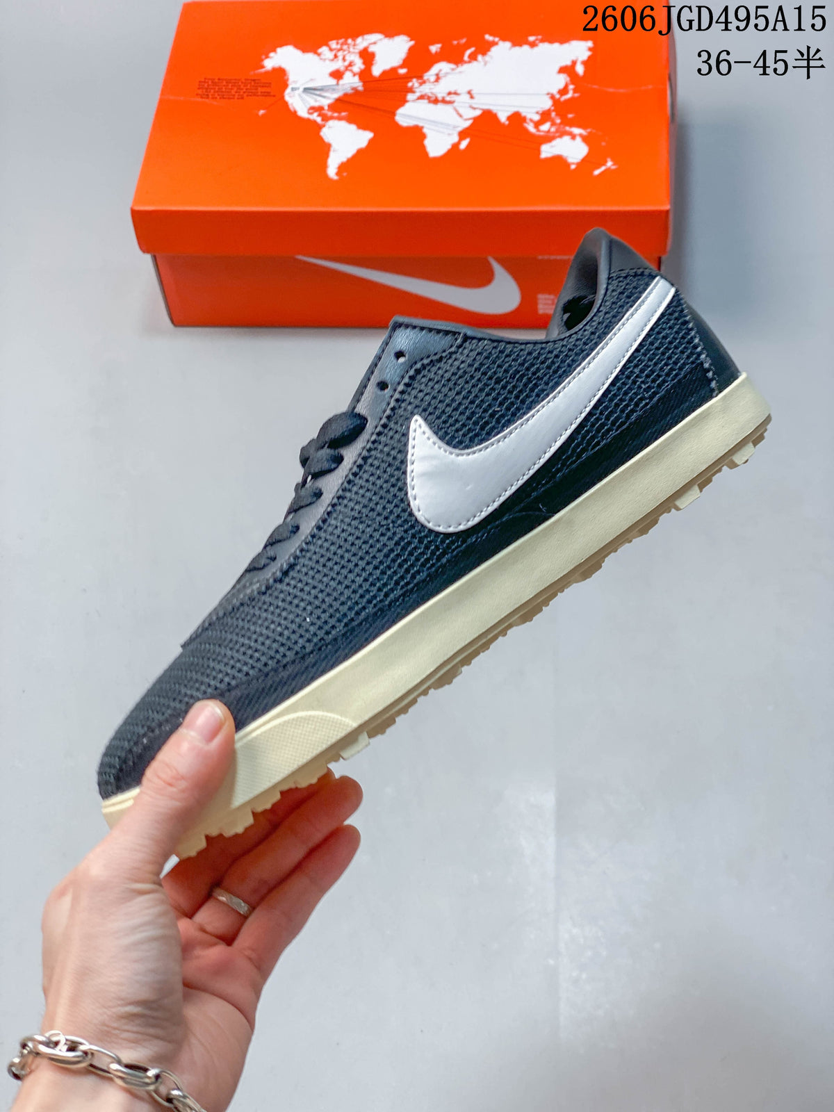Side view of a dark navy Nike Astro Grabber sneaker with a light-colored Swoosh logo and cream sole.