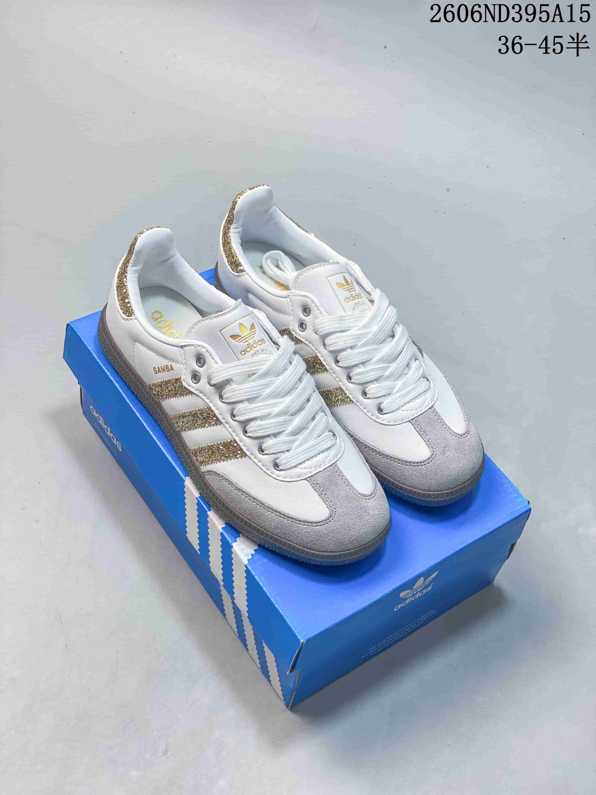 Pair of white low-top sneakers with gold-tone glitter stripes and gray suede-look toe panels