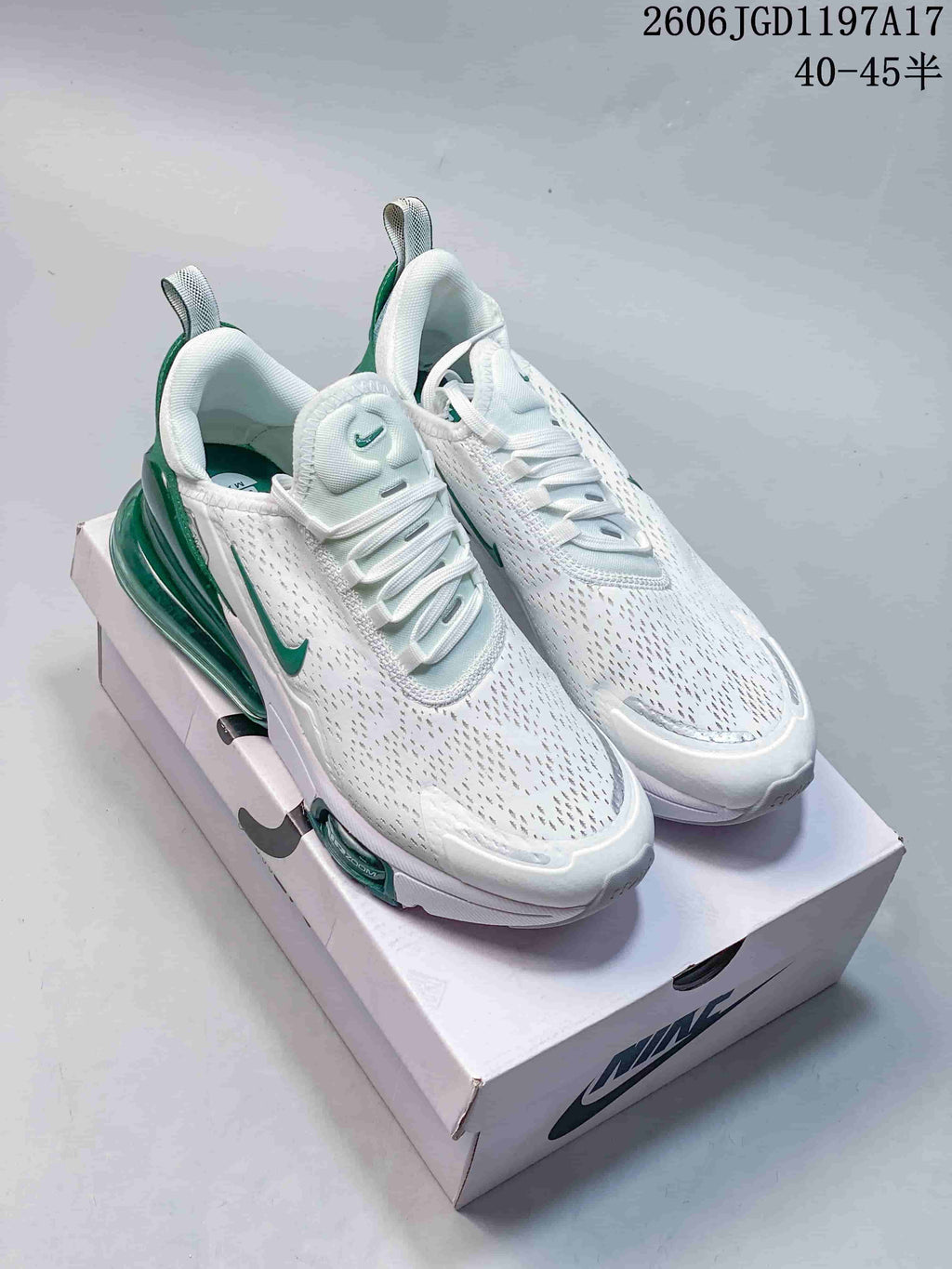 Pair of white and green Nike Air Max Pulse sneakers shown from above on a shoebox.