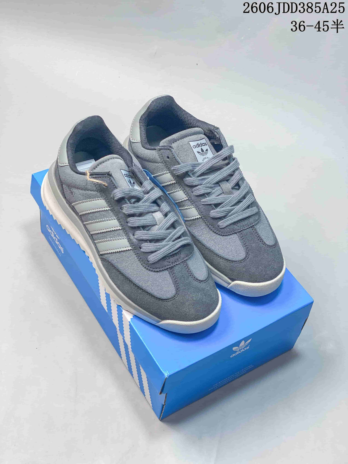 Pair of grey adidas SL 72 sneakers with three-stripe detailing, shown on a blue shoebox