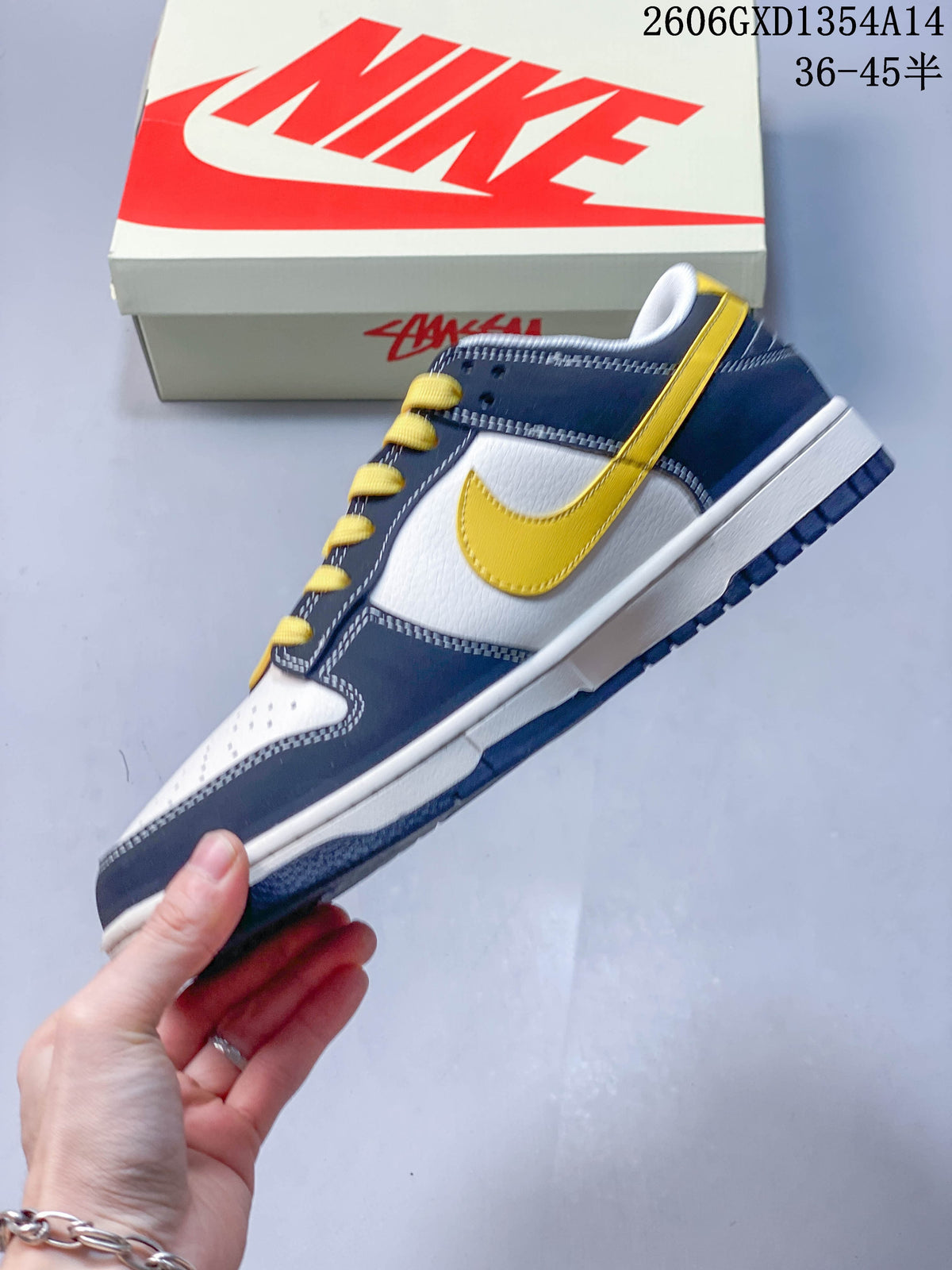 Side view of the low-top sneaker with a yellow swoosh, navy overlays and white panels.