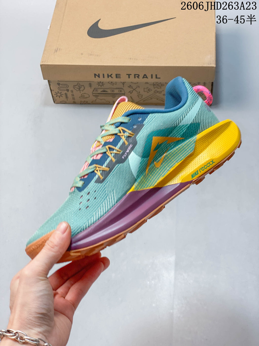 Side view of the teal Nike Pegasus Trail 5 with multicolor accents and a lugged outsole.