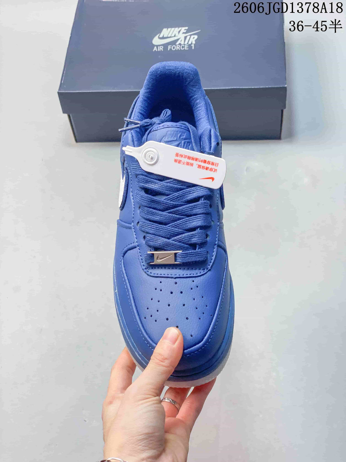 Front view of a blue sneaker showing the perforated toe and lace tag