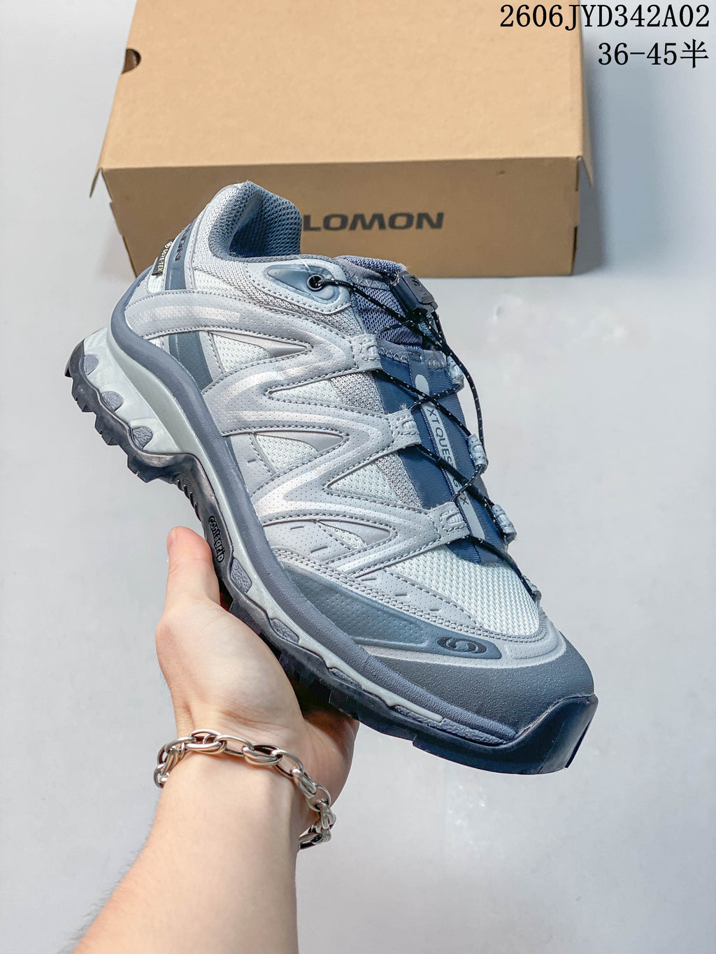 Side view of a silver-grey Salomon trail-style shoe with a lugged outsole