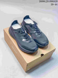 Pair of dark gray Descente low-top running shoes on a branded shoebox