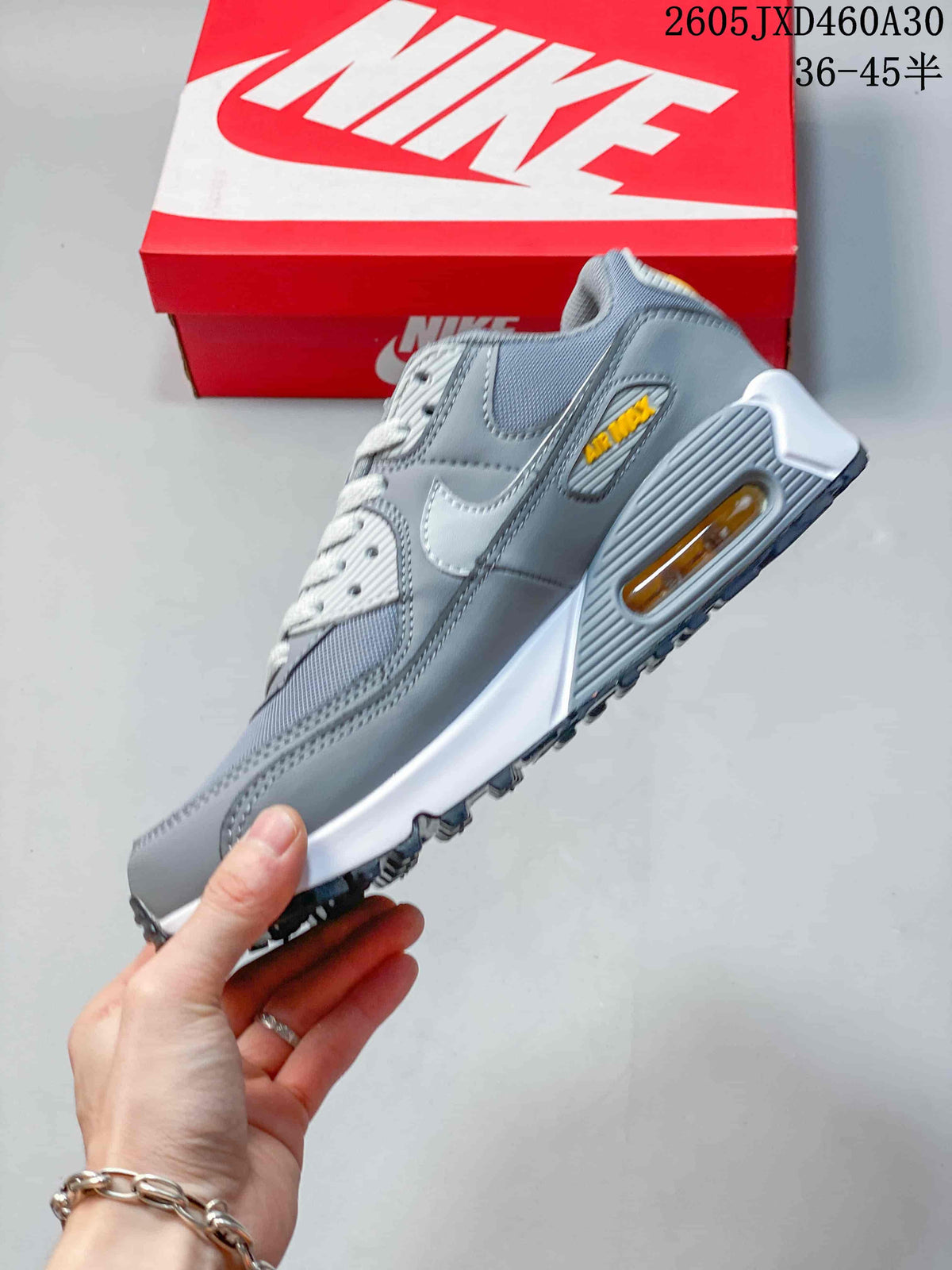 Side profile of the grey Nike Air Max 90 sneaker with a visible heel Air unit.