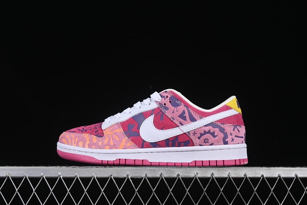 Side view of a multicolor printed low-top sneaker with a white Swoosh and pink outsole